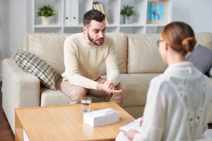 female therapist discussing with male patient does trauma lead to addiction