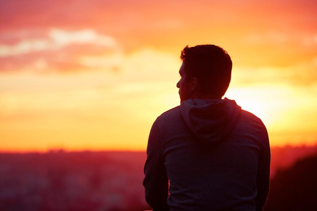 a person watches a sunrise wondering if you can be cured from addiction