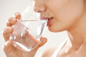 close up of a person taking a sip of water after discovering what are the most commonly abused painkillers